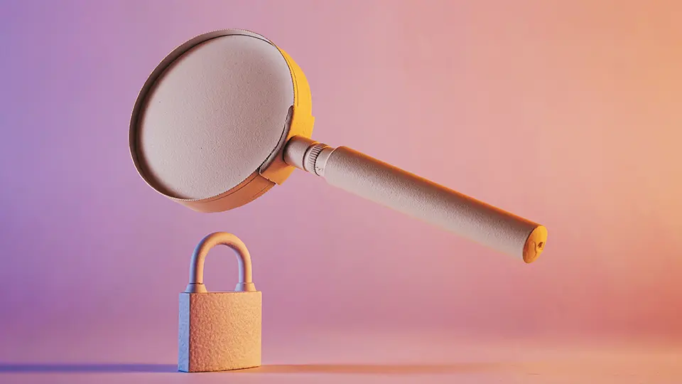 Una lupa situada encima de un candado sobre un fondo tenue para ilustrar un artículo sobre que es una auditoria en ciberseguridad